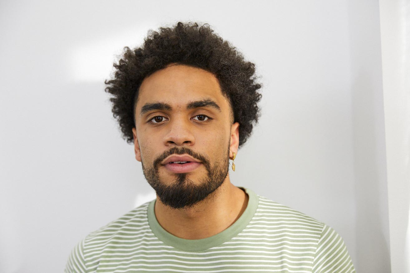 Ein junger Mann schaut nachdenklich nach vorne.