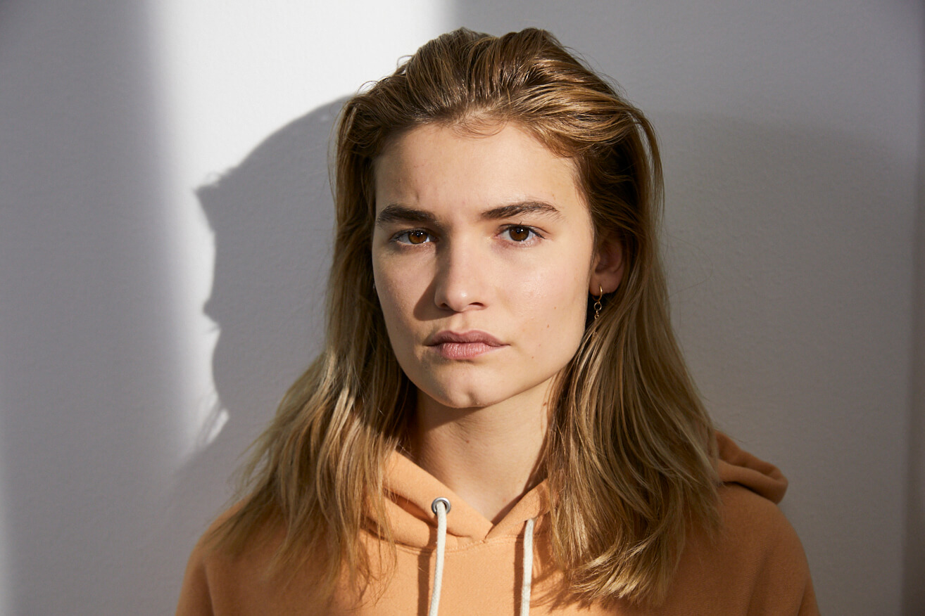 Eine junge Frau blickt skeptisch nach vorne.