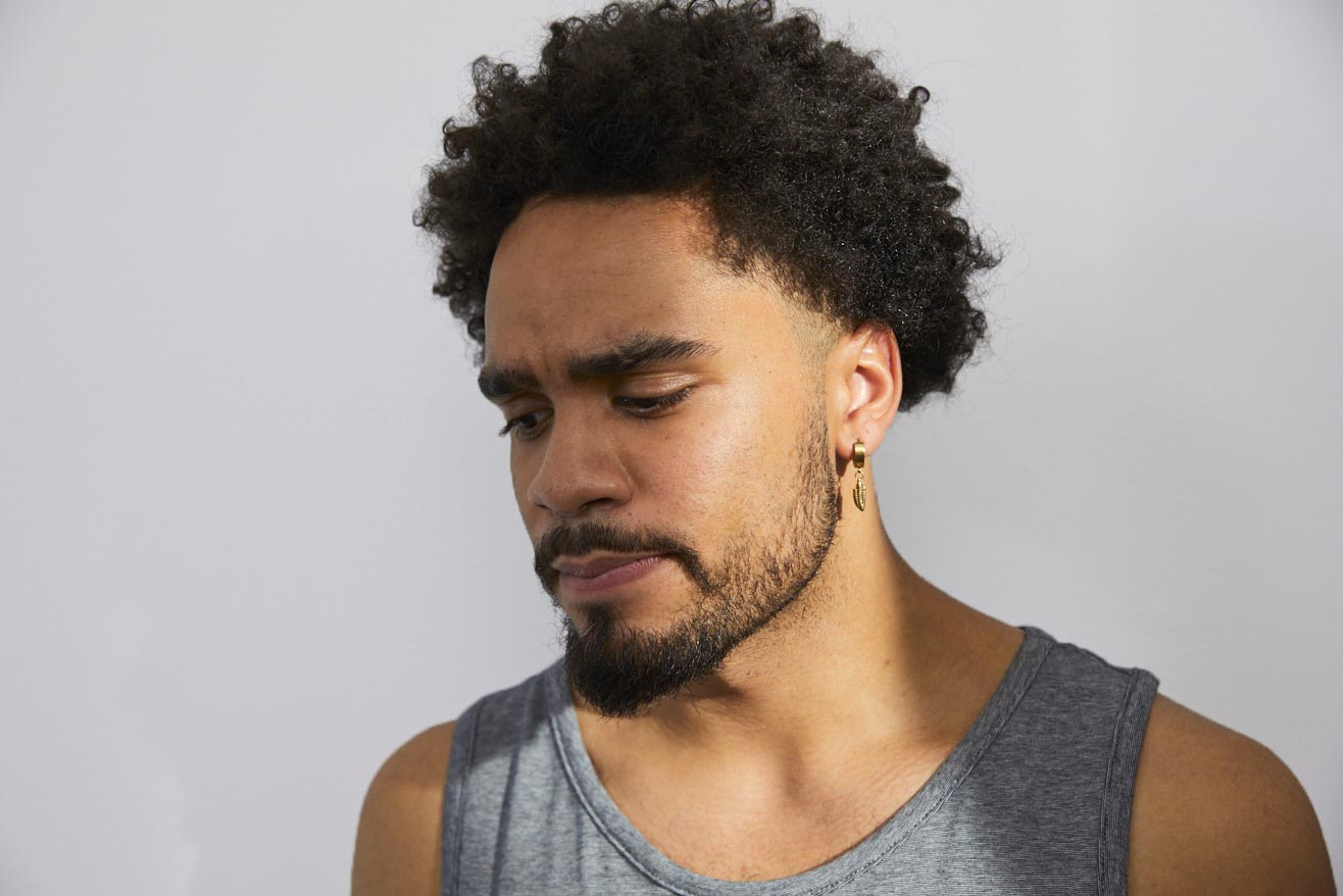 Ein junger Mann schaut nachdenklich nach unten.