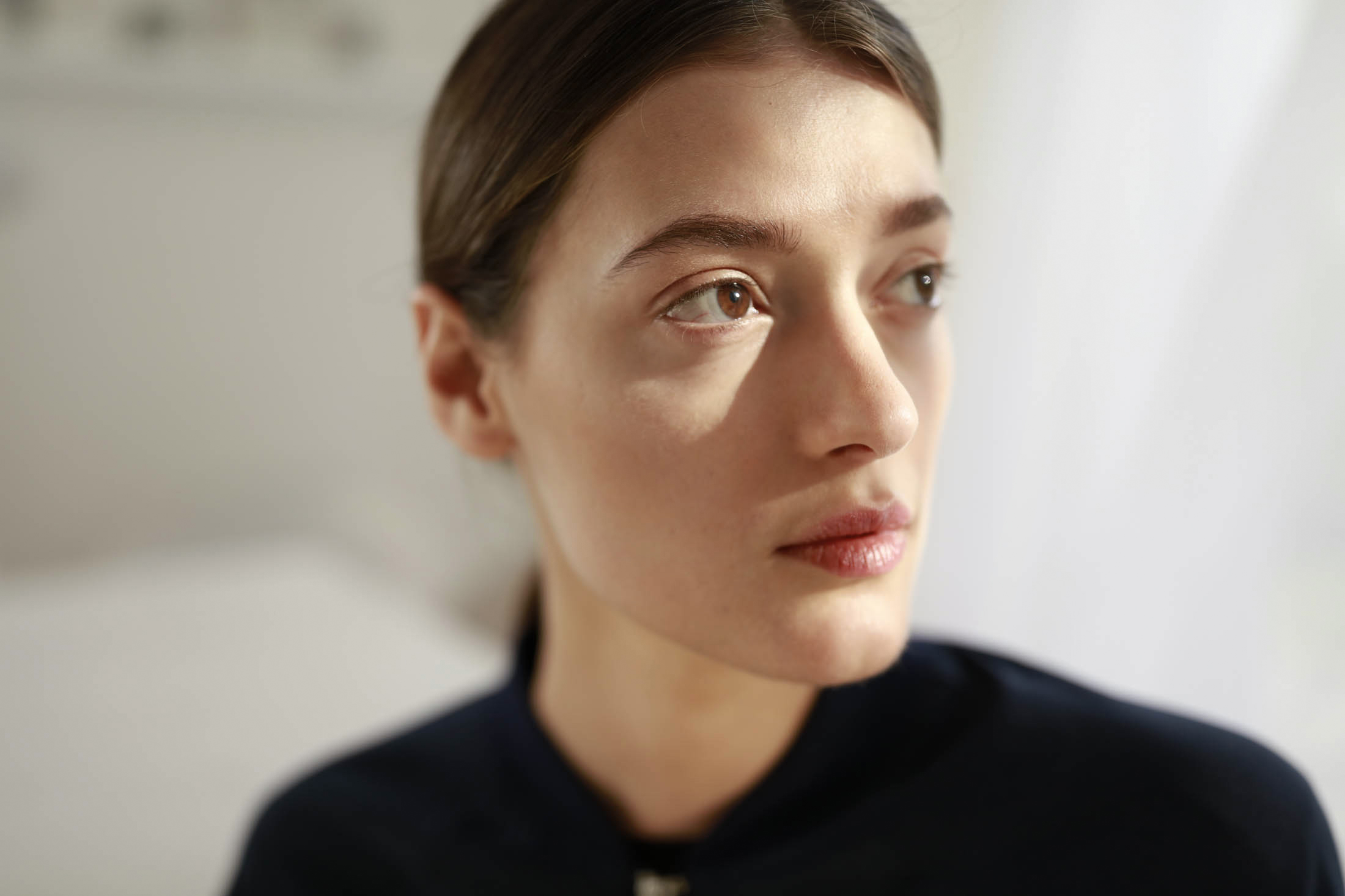 Eine junge Person schaut nachdenklich zur Seite.