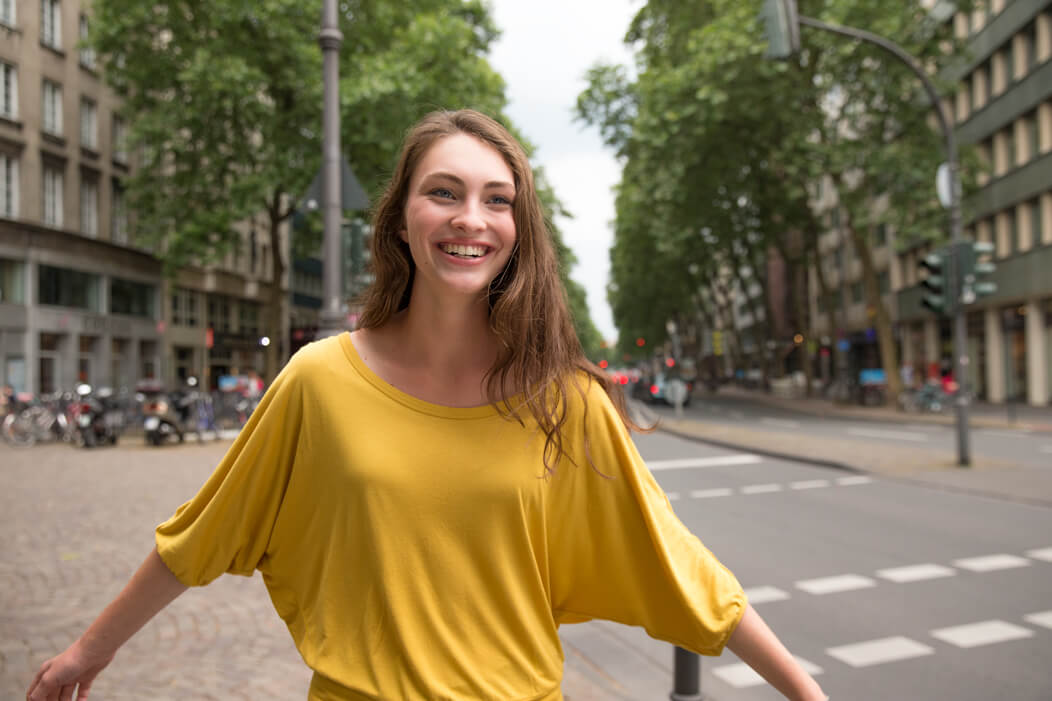 Das Bild zeigt eine junge Frau lachend.