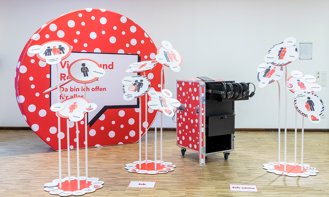 Parcours-Station »Vielfalt und Respekt – Da bin ich offen für alles.« mit einem Tablet, Kopfhörern und Infoschildern.
