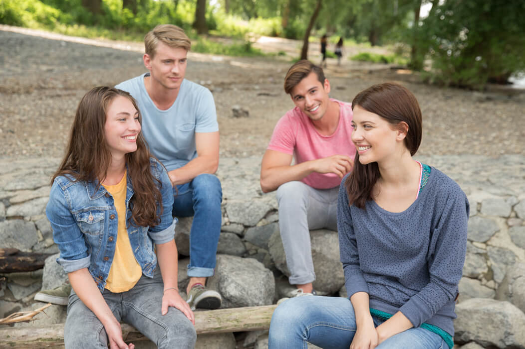 Eine Gruppe junger Menschen sitzt gemeinsam im Park.