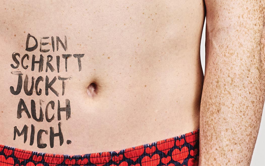 Eine Person mit Sommersprossen, auf deren Bauch der Text 